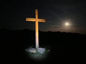 Night view of Jesus cross and a moon behind