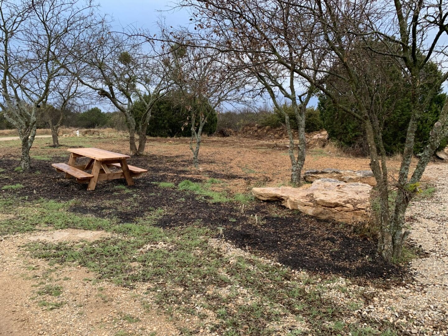 A wooden picnic table in the farm field