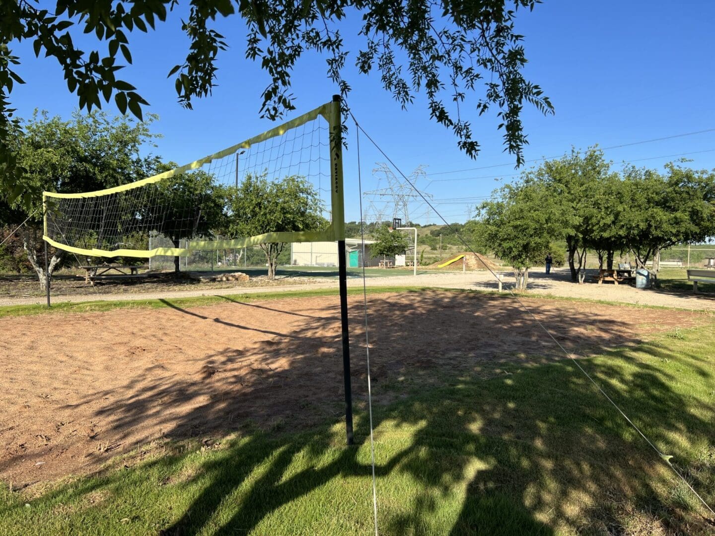 A volleyball net in the middle of an empty field.