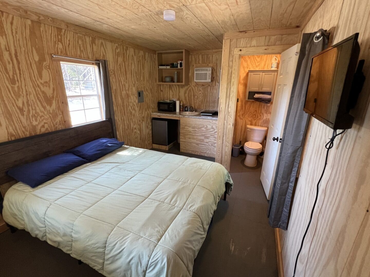 A bedroom with a bed, toilet and sink.