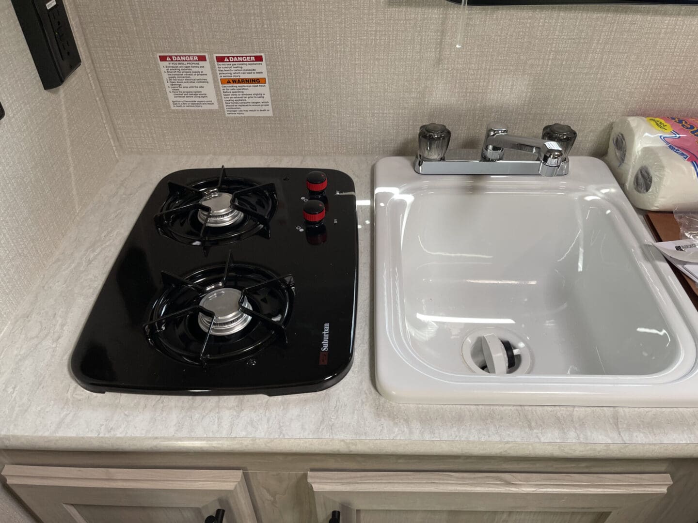 A black and white stove top next to a sink.