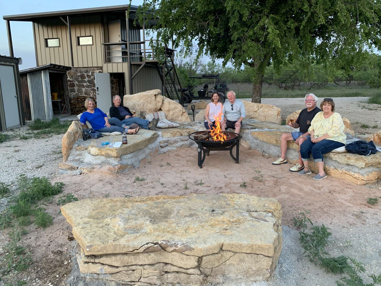 Couples posing for a picture with firepit in the foreground