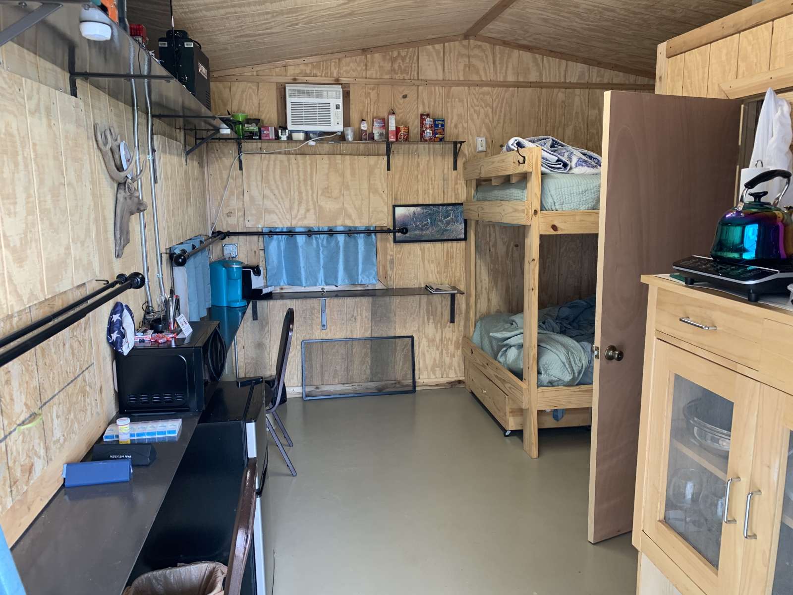 A room with bunk beds and desk in it