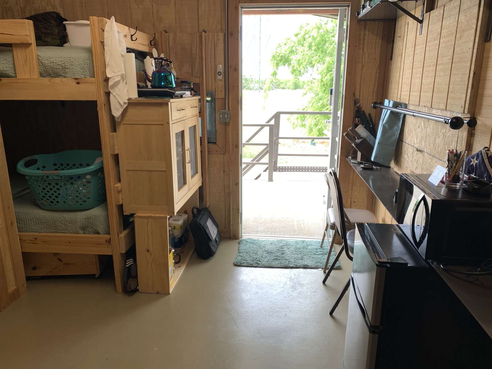 A room with two bunk beds and a desk.