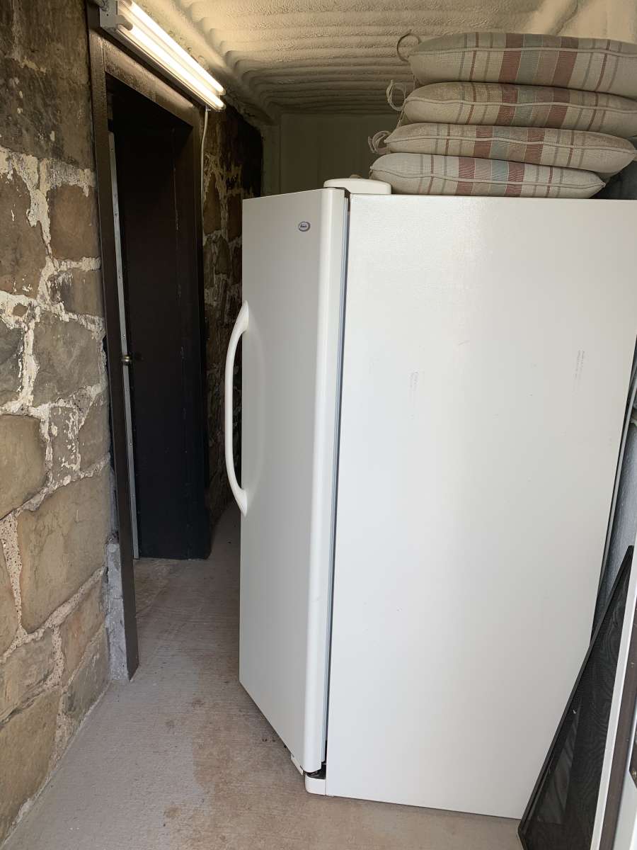 A white refrigerator freezer sitting in the middle of a room.