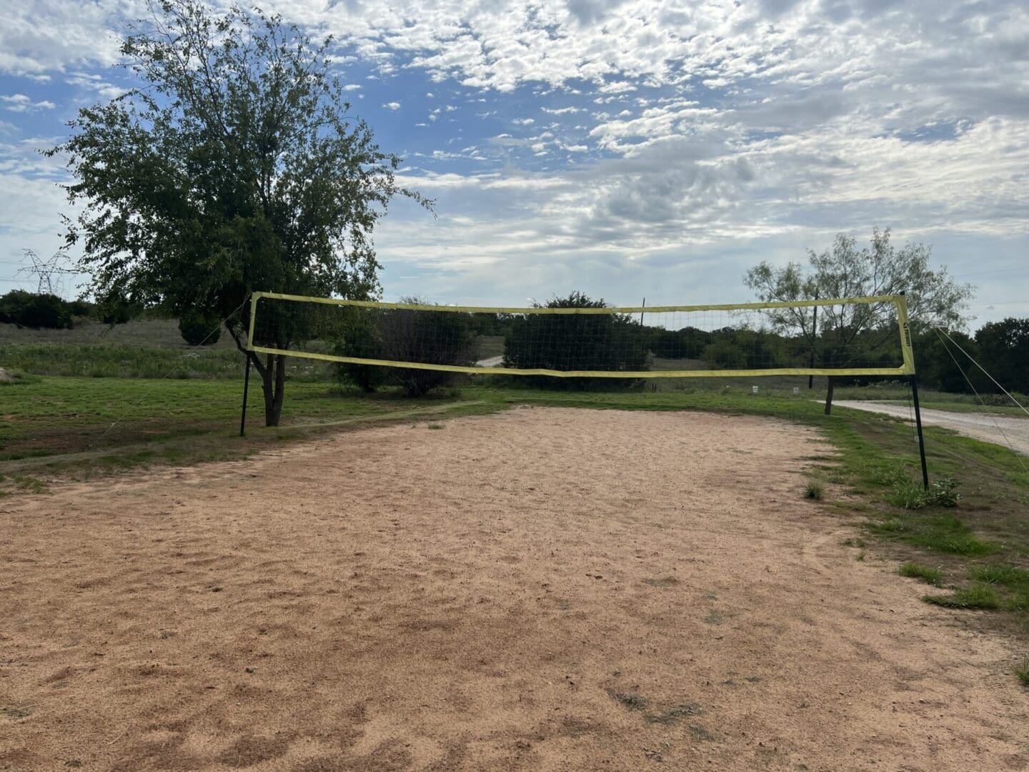 A volleyball net in the middle of an empty field.