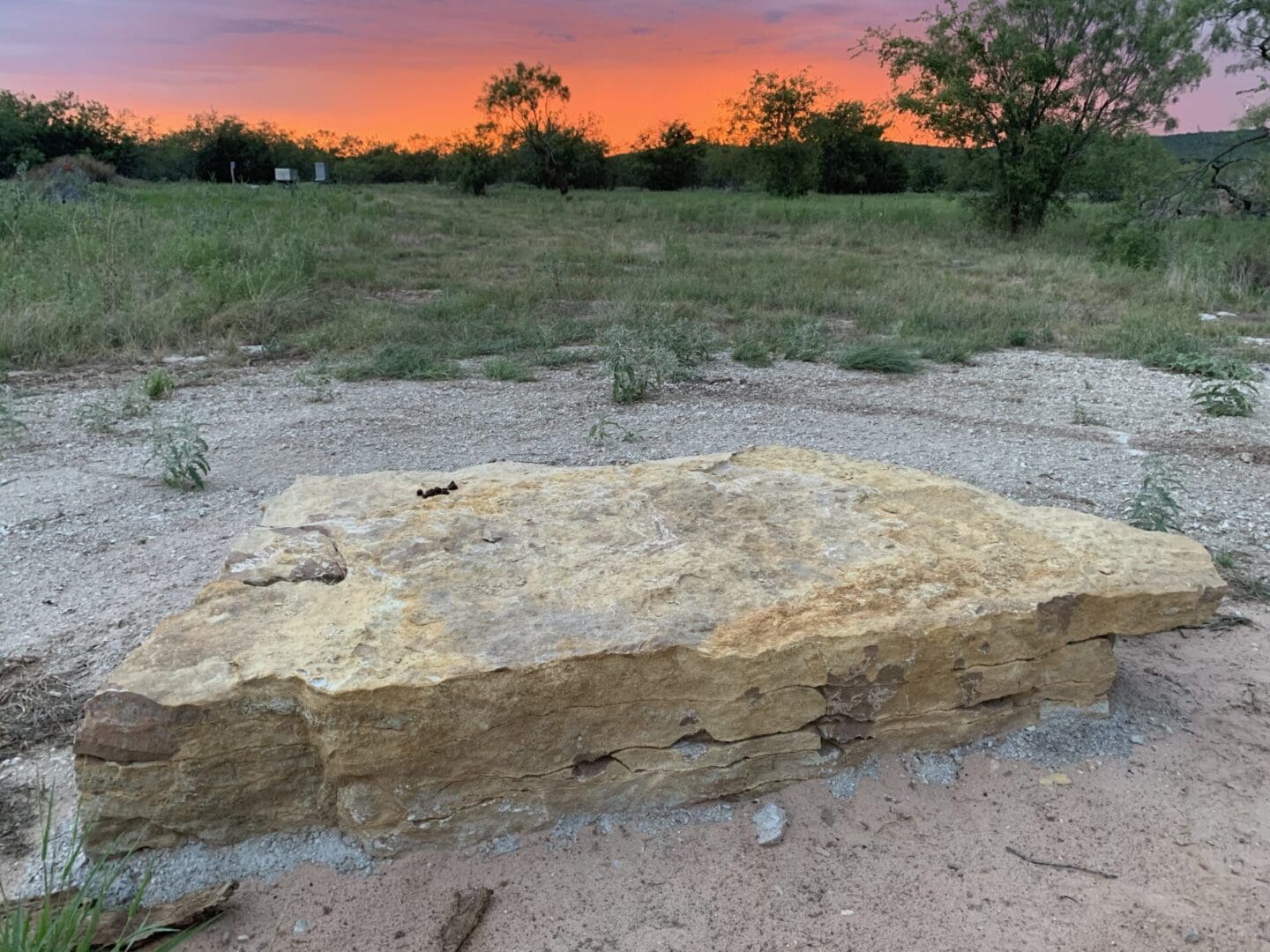 A stone slab sitting in the middle of a field.