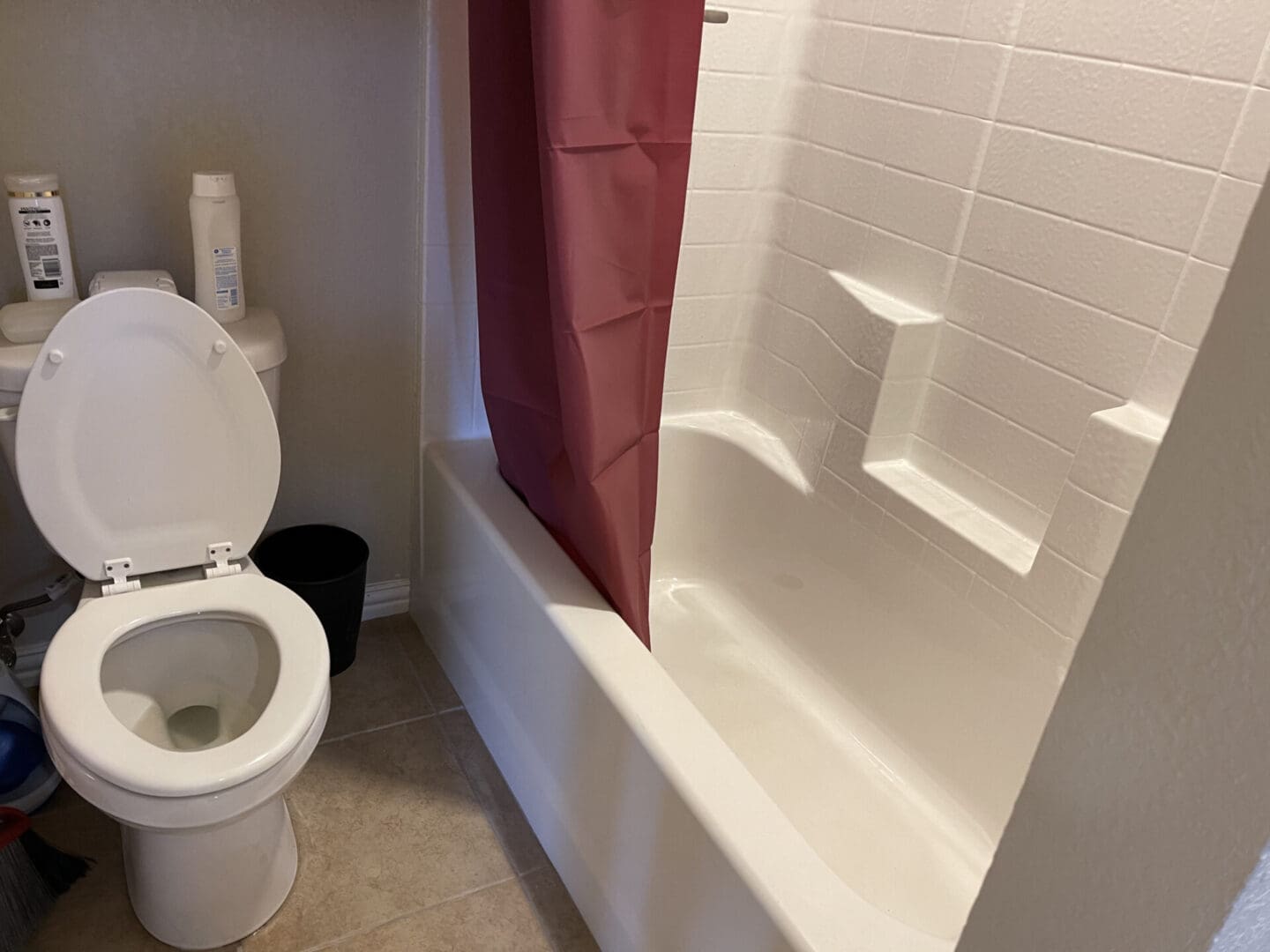 A bathroom with toilet, tub and shower.